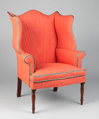 An easy chair with red-orange upholstery tapered mahogany legs